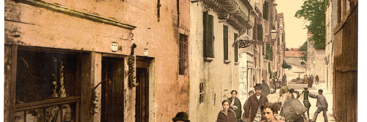Scena di vita in calle Seco Marina a San Giuseppe, con negozio di verdura e persone