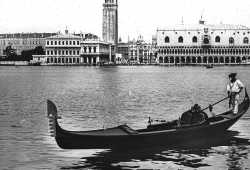 Un gondoliere in posa con la sua gondola nel bacino di San Marco con la sfondo meraviglioso di Piazza San Marco (Brooklyn Museum).